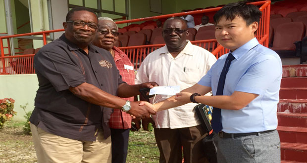 CHEC's Mr Kevin Wang hands over a cheque to Coordinator of the clean-up activities, Mr Larry London. Looking on are Chairman of the Guyana-China Business Council, Mr Clinton Williams (second left); and Assistant Coordinator of the clean-up activities, Mr Bobby Vieira