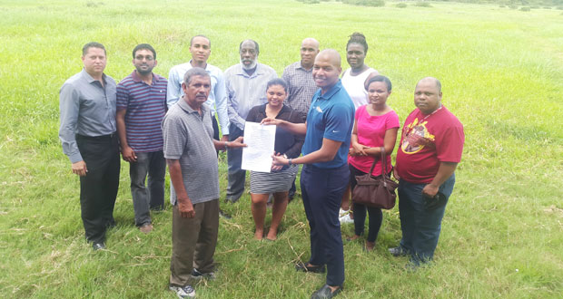 Normalisation Committee Chairman Clinton Urling collects the signed 30-year lease from an Eccles/Ramsburg NDC member in the presence of other representatives from the NDC and the GFF.