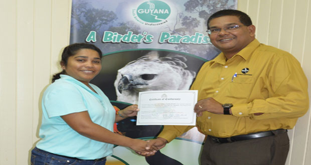 Old Fort’s Ms. Camille Boodhoo receiving the certification from GTA’s Mr Indranauth Haralsingh