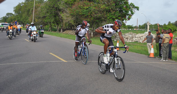 Team Evolution’s Michael Anthony crosses the finish line ahead of his team mate Orville Hinds to win the second stage of the 33rd Annual Three Stage cycle road race yesterday (Delano Williams photo).
