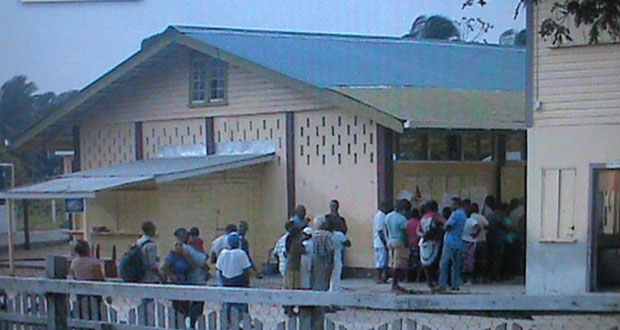 Voters waiting to exercise the franchise at a school on the Essequibo  Coast