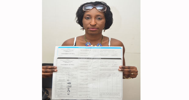 June Ann Gibbs displaying the Statements of Polls for the centre she managed on Elections Day