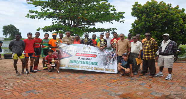 Minister of Education Dr. Rupert Roopnarine (fourth from right), race organiser Hassan Mohamed (third from right) and Chairman of the National Sports Commission, Conrade Plummer (sixth from right) strike a pose with the prize winners of the 33rd annual three-stage cycle road race yesterday the Carifesta Sports Complex yesterday.