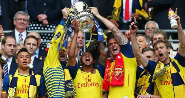 Arsenal's Olivier Giroud and Theo Walcott celebrate with the trophy after winning the FA Cup Final as team mates and Duke of Cambridge, Prince William look on. Reuters / Eddie Keogh