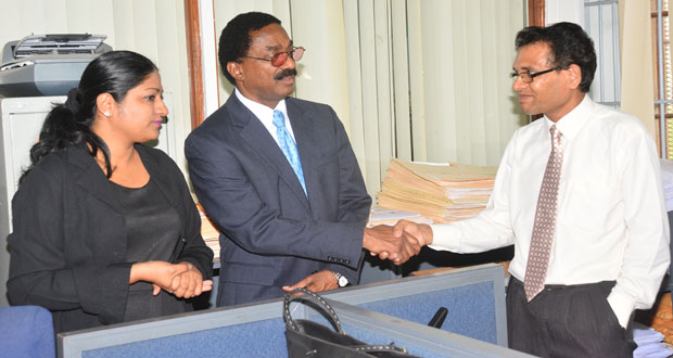 from left, Registrar of the Deeds Registry, Azeena Baksh, introduces AG Williams to one of the staffers.