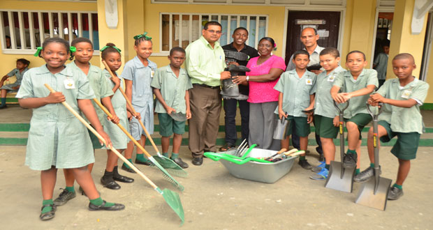 GTA’s Director Indranauth Haralsingh hands over tools to Clive Muridalall, Georgina Lewis and some of the members of St. Margaret’s Primary School ECHO club (Photos by Adrian Narine)