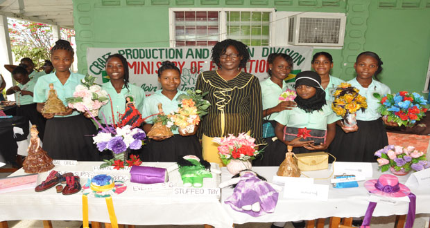 A teacher poses with some of the students and their African dolls and floral arrangements at yesterday’s exhibition