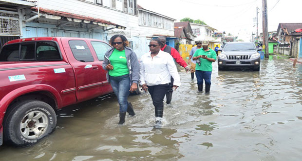 Minister within the Ministry of Public Infrastructure, Ms Annette Ferguson, and Minister
within the Ministry of Social Protection, Ms
Simona Broomes, assessing the damages
of yesterday’s deluge in one of the affected
neighbourhoods (Photo courtesy of GINA)