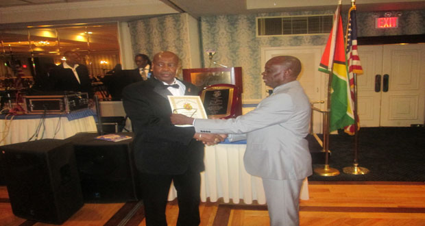 Newly-elected President of the Guyana Ex-police Association of America Leroy Charles (right) presents the Presidential Award to outgoing President, Leon Gibbons