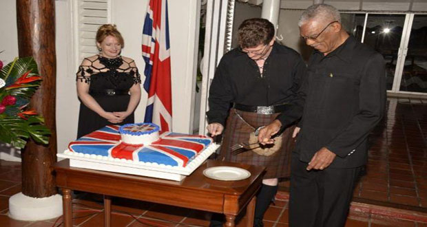 Mrs. Wendy Quinn, British High Commissioner Greg Quinn and President David Granger cutting a Union Jack themed cake at the celebration to mark the 89th birthday of Queen Elizabeth 11