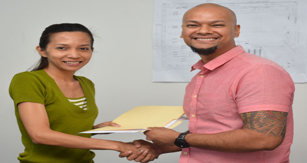 Marketing Manager of Giftland, Karen Agtarap hands over the agreement to ‘Publik Wing and Burger House’ owner Sean Major, yesterday (Samuel Maughn photo)