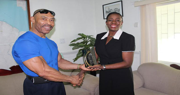 Hugh Ross (left) receives his plaque of appreciation from Minister within the Ministry of Education Nicolette Henry.