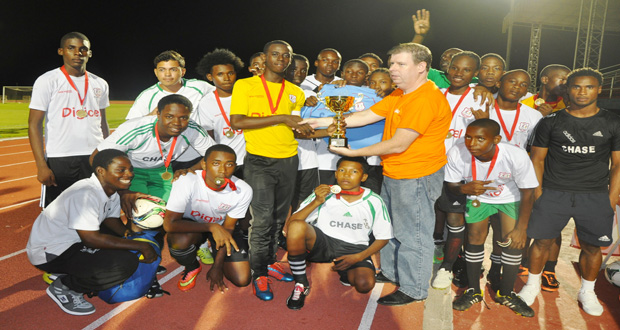 Digicel Guyana Kevin Kelly hands over the winning trophy to Chase Academy following their 4 – 2 win over Morgan Learning Centre.