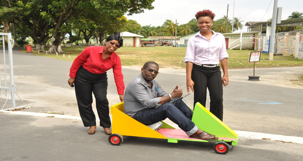 Ms Denise Fraser, Deputy Commissioner, Guyana Protected Areas Commission pushes Pastor Terrence Esseboom around in the go-kart, handed over by Attallah Wilson of the National Go-Kart Derby. (Photo by Delano Williams)