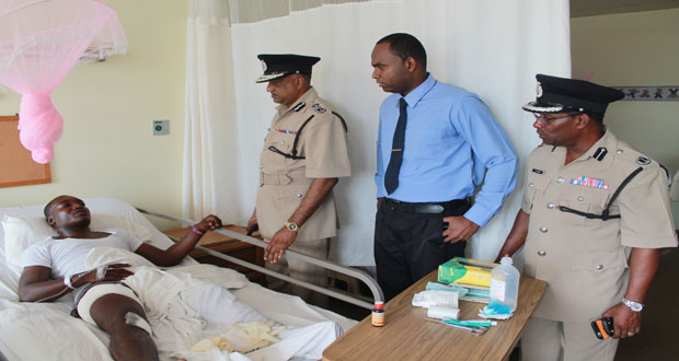 The injured police rank convalescing at the hospital. Paying him a visit are, from right, Assistant Commissioner of Police, Mr Clifton Hicken; Senior Superintendent Wendell Blanhum; and Commissioner of Police, Mr Seelall Persaud