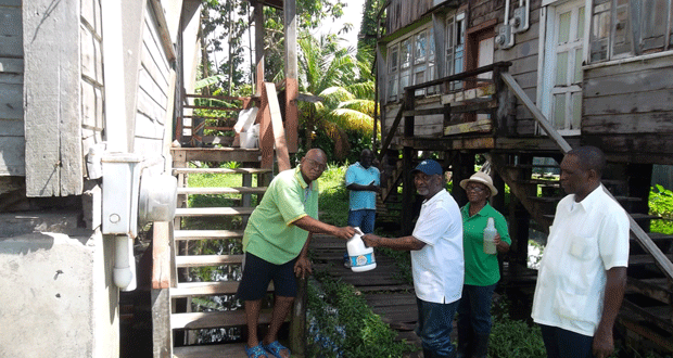 The minister gives detergent to a resident of Hadfield Street