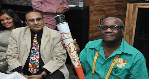 GOA president K. Juman Yassin (left) and Chef de Mission Ivor O’Brien pose with the Pan Am Games torch.