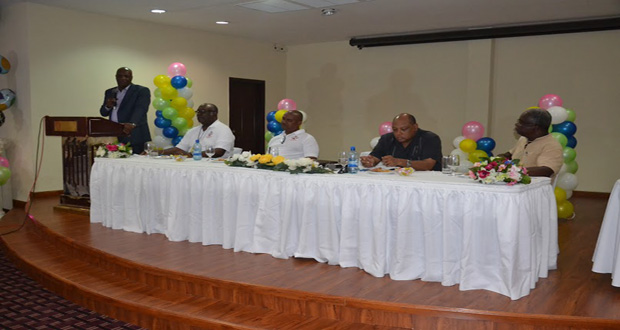 Minister of State Joseph Harmon addressing the gathering; also in the picture at the head table are: (from left) Mr. Newell Dennison, Chairperson; Mr. Rickford Vieira, Commissioner, GGMC; Minister of Governance, Raphael Trotman; and Dr. Grantley Walrond, Former Commissioner, GGMC.