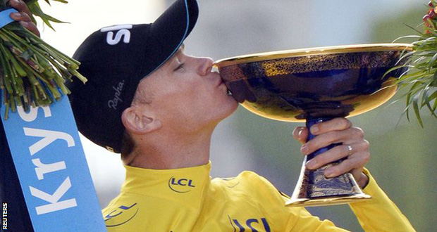 Chris Froome celebrates by kissing his newly acquired Tour de France trophy.