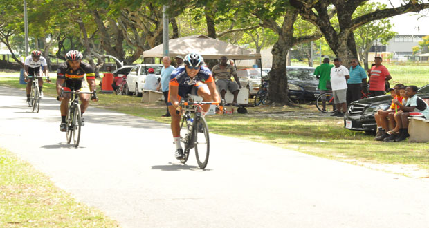 Paul DeNobrega (right) crosses the finish line ahead of Robin Persaud to win the P&R Insurance and Consulants’ sponsored feature 35-lap cycle race in the National Park yesterday (Photo by Delano Williams).