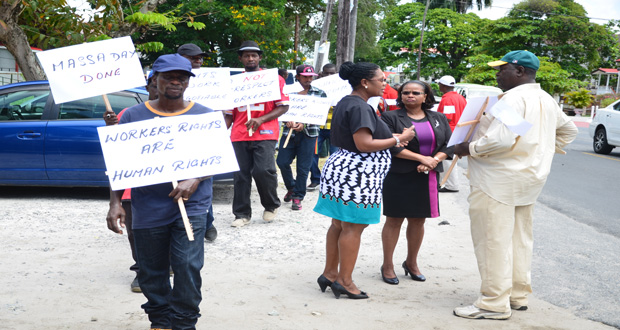 Minister of Social Protection, Volda Lawrence, in conversation with one of the dismissed workers as several others picket outside the ministry’s office