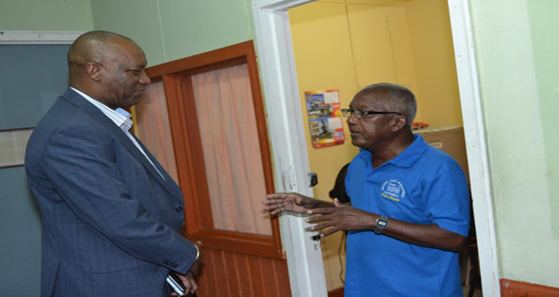 Minister of State Joe Harmon interacts with a staff member of the National Data Management Authority on Friday last (Jules Gibson photo)