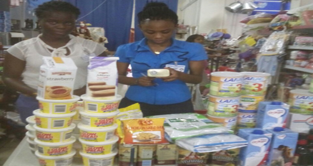 Two GAD staffers with some of the expired foodstuff  that were seized and destroyed