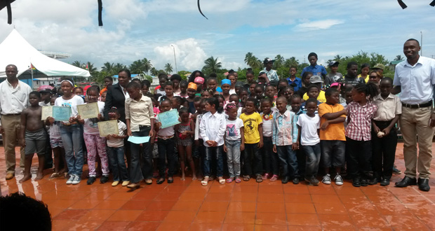 Participants of the MCYS/NSC August Vacation Swimming Programme pose with the Minister in the Ministry of Education, with responsibility for Sport, Nicolette Henry, and Director of Sport Christopher Jones (right). At extreme left is Permanent Secretary Alfred King.
