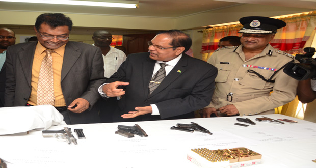 From left are Minister of Public Security, Khemraj Ramjattan, and First Vice President and Prime Minister, Moses Nagamootoo. They are inspecting firearms and ammunition in the presence of Police Commissioner Seelall Persaud.