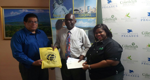 Carl Bowen (left), Commercial and Marketing Manager, and Celia Steele (right), representative of Courtleigh Group of Hotels, pose with the winner of the weekend trip for two to Jamaica.