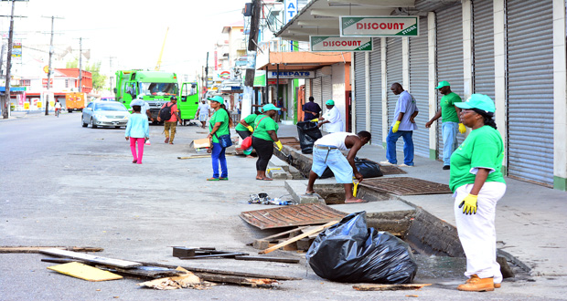 Persons working diligently to clean the drains along Regent Street as part of the ‘Green City’ initiative
