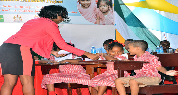 A teacher interacts with students at the launch of the Early Childhood Development Project