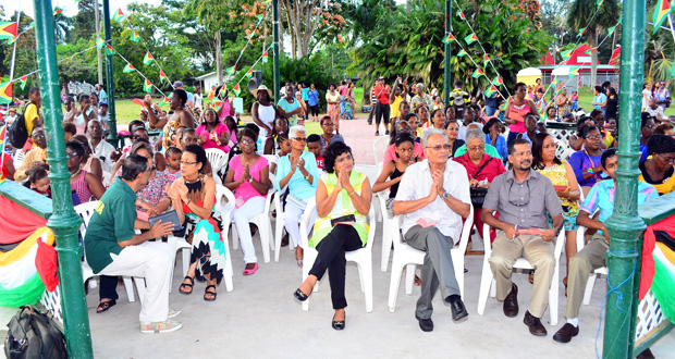 Education Minister Dr Rupert Roopnaraine (third right) applauds, as a member of the audience gathered at the national steelpan show at the Botanical Gardens on Sunday