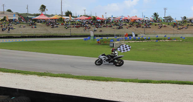 Stephen Vieira carries the chequered flag after winning one of his CMRC races. (Photo by S.E.A.G. Productions’)