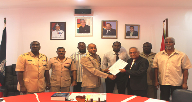 President of the Guyana Bar Association Christopher Ram hands over a copy of the “Rights of Arrested Persons” to Commissioner of Police Seelall Persaud