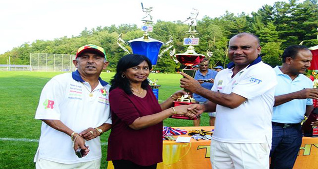 GFSCA skipper Rickey Deonarine collects the runner-up trophy for the Masters category. President Ramchand Ragbeer is at left.