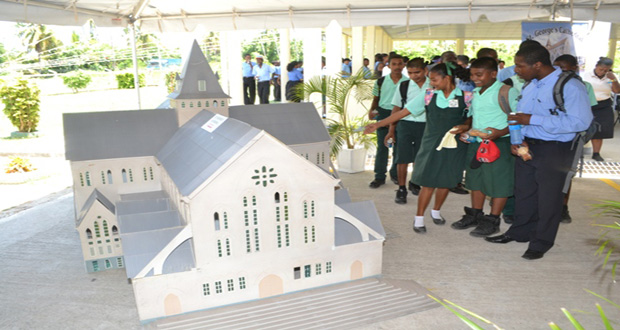 Students viewing a model of the St. Georges Cathedral, tallest wooden building in the world