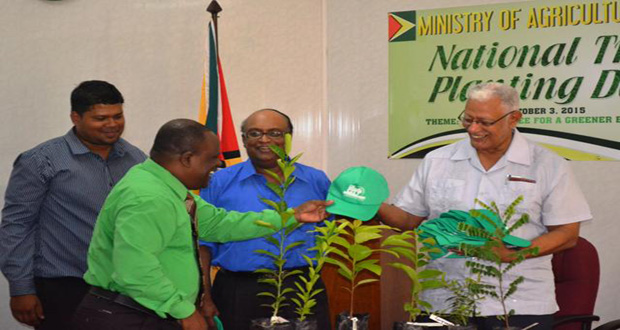 Hon. Minister Noel Holder handing over young trees to Town Clerk Royston King at
the National Tree Planting Day Launch