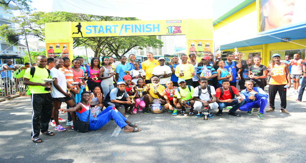 Prize-winners of the various categories of the 5th Annual COURTS 10K road race show off their silverware. (Photo by Samuel Maughn)