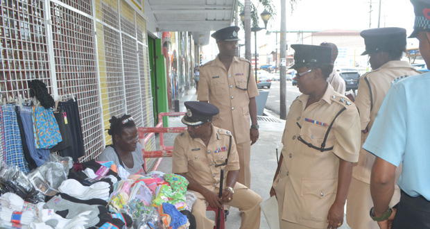 Commander Hicken interacts with a pavement vendor along Regent Street