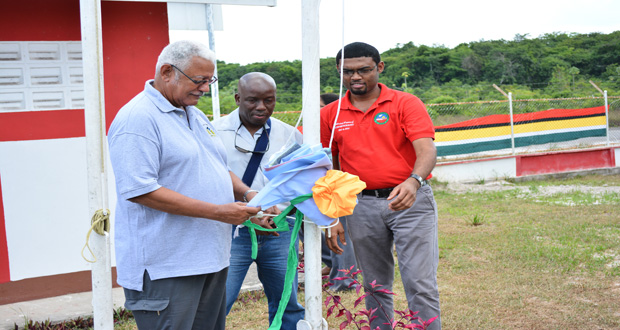 Permanent Secretary in the Agriculture Ministry, George Jervis and the Chief Hydrometeorological Officer, Dr. Garvin Cummings assisting subject Minister, Noel Holder in raising the flag