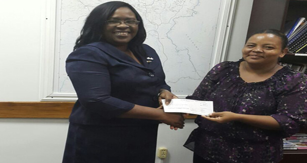 Minister Cummings hands over the cheque to Treasurer of the Mabaruma Heritage Committee, Amanda Gomes