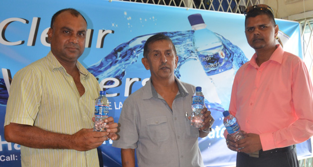 Marketing, Sales and Distribution manager of Clear Waters, Narendra Lucknauth (right), GFSCA president Ramchand Ragbeer (centre), and vice-president of the GFSCA, Ricky Deonarain, display a bottle of Clear Waters.