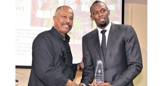 Vice Chancellor of the UWI Professor Sir Hilary Beckles (left) presents Usain Bolt with the inaugural UWI Vice Chancellor’s Alumni Exemplar Sports Award at the institution’s regional headquarters at Mona last Thursday. (Jamaica Observer photo).