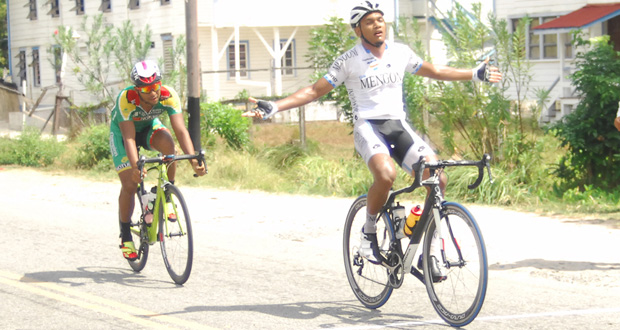 Roraima Bikers’ Alonzo Greaves celebrates winning the fourth stage of the `Tour of Guyana’ cycle road race yesterday on the Essequibo Coast. Following closely behind Greaves is Geron `The Lone Soldier’ Williams who placed second in the stage