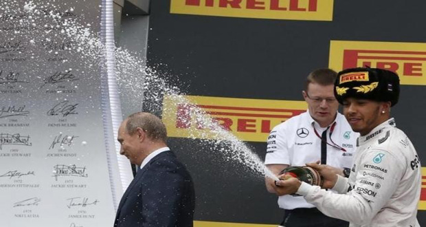 Russian President Vladimir Putin (L) leaves the winners’ podium as Mercedes Formula One driver Lewis Hamilton of Britain (R) sprays champagne in celebration after winning the Russian F1 Grand Prix in Sochi, Russia, Sunday. (Reuters/Grigory Dukor)