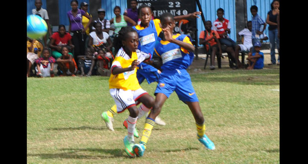 St Angela’s Primary School’s Keon Douglas in battle during his side’s 1–0 win over West Ruimveldt Primary in yesterday’s COURTS Pee Wee Under-11 Schools football semi-finals.