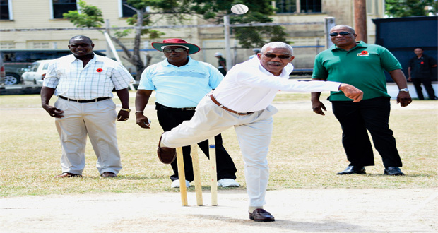 Off-spin? Leg-spin? President David Granger bowls the first ball to start off the game yesterday at the Police Sports Club ground, Eve Leary. (Samuel Maughn photo)