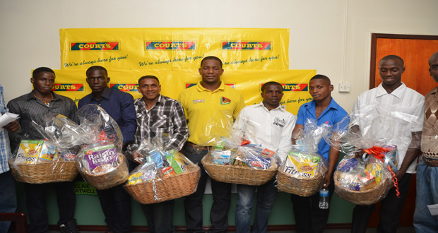 In this Delano Williams photo, six of the eight amateur boxers who received hampers, compliments of COURTS Guy Inc., strike a pose with GBA president Steve Ninvalle (extreme right) and GBA’s technical director Terrence Poole (extreme left).
