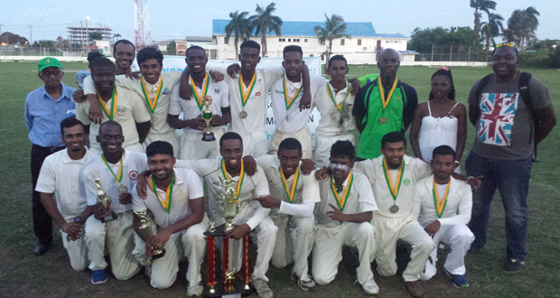 A jubilant University of Guyana team celebrate with the Noble House Seafoods trophy after their exciting win over Transport Sports Club on Sunday.